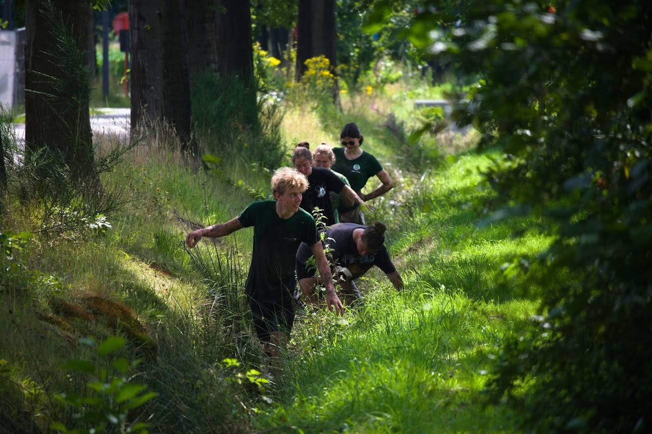 Vier personen achter elkaar in een beek 